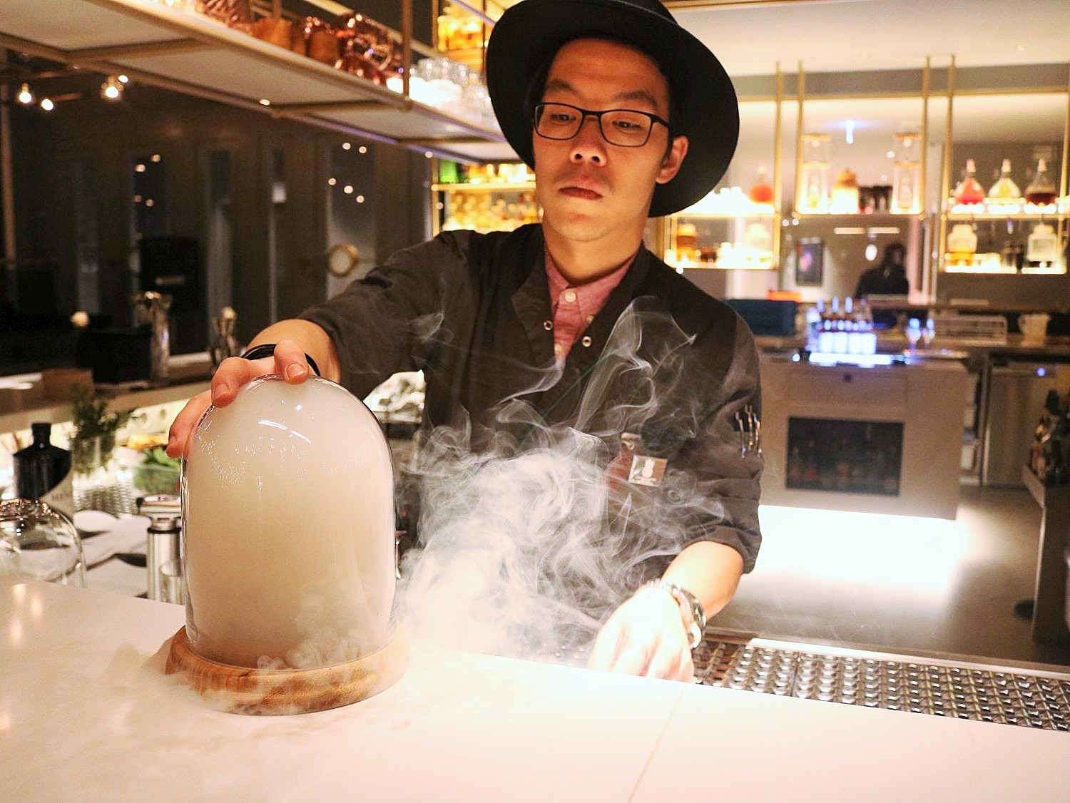 Barkeeper mixt Cocktail mit Rauch an der Bar