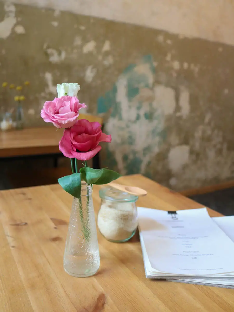 Tisch mit Vase und zwei ros farbenen Rosen