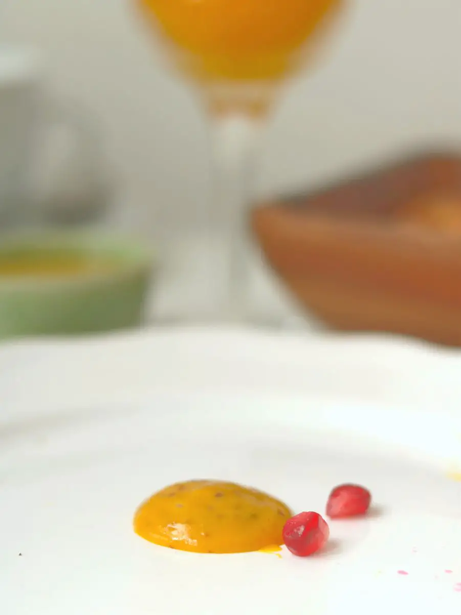 Ein Klecks Orangen-Senf Sauce auf einem weißen Teller