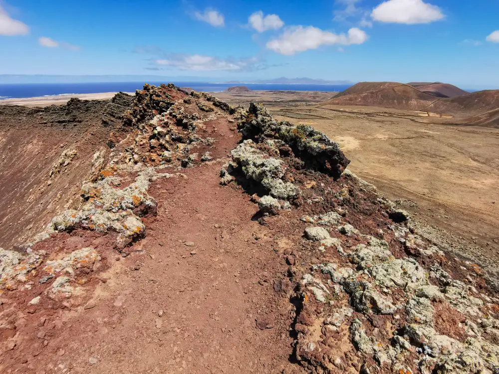 Wandern auf dem Calderon Hondo im Norden der Insel Fuerteventura. Roter Sand, Felsen und ein traumhaften Panoramablick bis hin zum Meer.